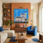Preview: Kunstdruck Bonn-City in Blau in Wohnzimmer mit orangefarbener Wand, Regal und blauem Sessel.