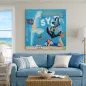 Preview: Leinwandbild Sylt mit Inselkarte und maritimen Motiven über blauem Sofa im Küsten-Wohnzimmer